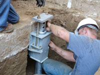 Foundation repair contractors installing the foundation bracket in Alexandria.