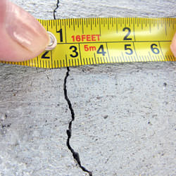 A crack in a poured concrete wall that's showing a normal crack during curing in Burke