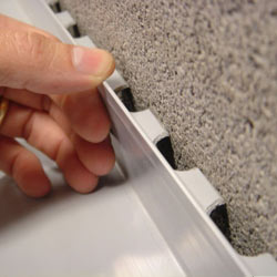 A contractor in McLean installing a perimeter drain tile system during a sump pump installation.